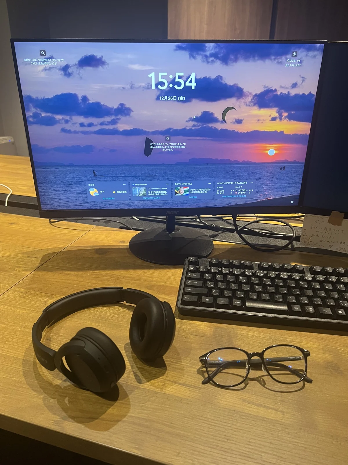 デスクに並ぶPCモニター、ヘッドホン、眼鏡